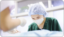 A woman in a hospital wearing a hair net and face mask