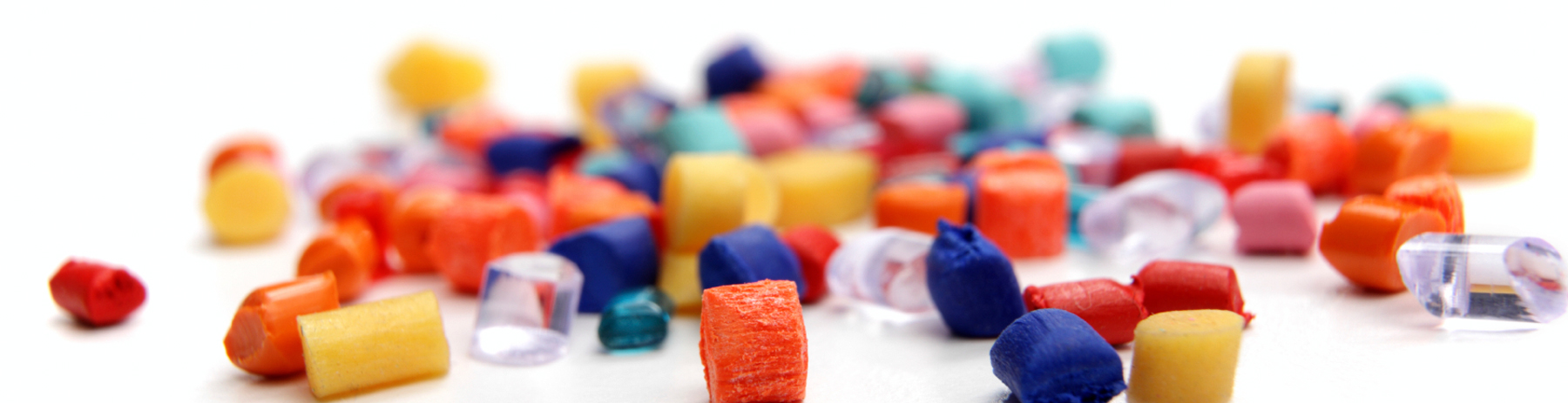 Pellets of recycled plastic on a white surface